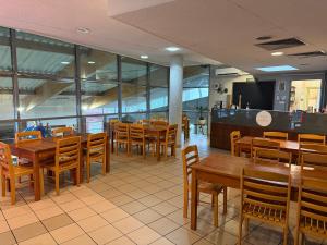 a restaurant with wooden tables and wooden chairs at Hotel Aqua Żyrardów in Żyrardów