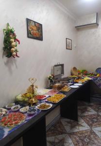 ein Buffet mit vielen Tellern mit Essen auf einem Tisch in der Unterkunft Art Home Hotel in Taschkent