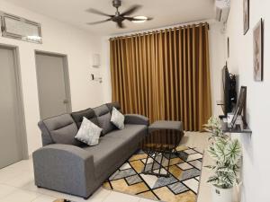 a living room with a couch and a television at Avida Homestay in Kampong Jelatang