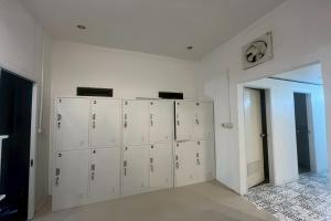 a room with white lockers and a wall at Lazy Lizard Hostel in Ban Nong Chaeng
