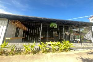 a black building with plants in front of it at Lazy Lizard Hostel in Ban Nong Chaeng