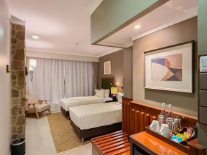 a hotel room with two beds and a couch at Wellworth Mikumi Wildlife Lodge in Morogoro