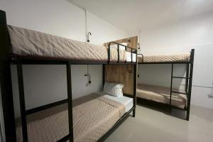 two bunk beds are in a room with at Lazy Lizard Hostel in Ban Nong Chaeng