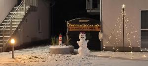 a snowman in front of a building with a christmas tree at Juliusruh Strandparadies 6 in Juliusruh