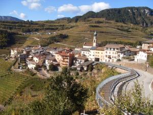 un pueblo en una colina con un tren pasando en B&B alla Villa, en Giovo