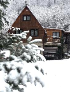 a house covered in snow in front at Chata Jánošík in Terchová