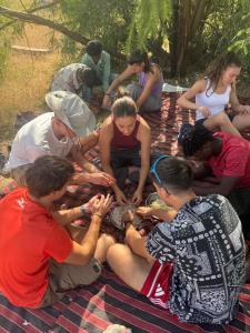 Un gruppo di persone sedute su una coperta di Farm house , jaisalmer a Jaisalmer