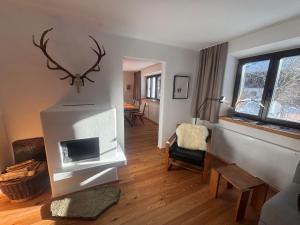 Una sala de estar con chimenea y televisión. en Tilli´s Garten, en Scharnitz