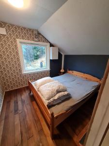 1 dormitorio con cama de madera y ventana en AMO Svartisen Guesthouse, 