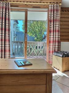 ein Holztisch mit einem Buch auf einem Fenster in der Unterkunft Au cœur de Chamonix, La Ginabelle, Calme avec Piscine, Sauna et Garage in Chamonix-Mont-Blanc