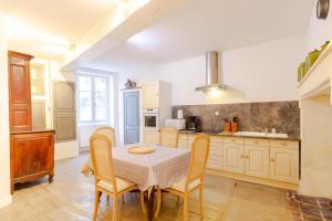 a kitchen with a table and chairs in a room at Charme et Elegance a Bourdeilles in Bourdeilles