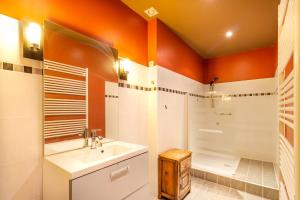 an orange and white bathroom with a sink and a shower at Charme et Elegance a Bourdeilles in Bourdeilles