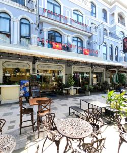 a patio with tables and chairs in front of a building at BREAKING DAWN- TAEYANG Hotel Phú Quốc in Phú Quốc