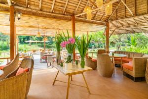 um restaurante com mesas, cadeiras e flores num pátio em The Riverfront Reserve em Pai
