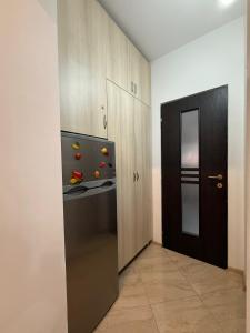 una cucina con frigorifero nero e armadietti in legno di Straja Mountain Escape a Lupeni