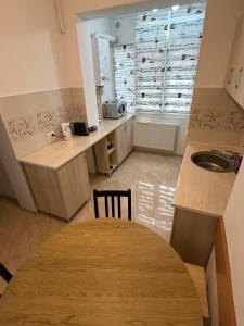 a kitchen with a wooden table and a sink at Straja Mountain Escape in Lupeni +14 photos