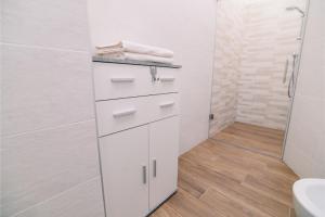 Un baño blanco con lavabo y ducha en B&B alla Villa, en Giovo 6 fotos más