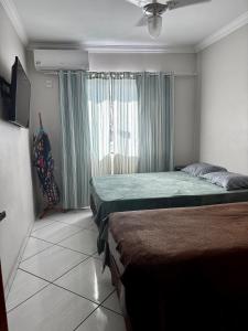 a bedroom with two beds and a window at Suíte férias in Cabo Frio