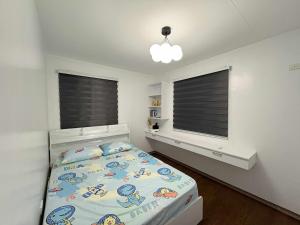 a bedroom with a bed and two windows at Solana Zaragoza house for lease in Capaya