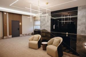a lobby with two chairs and a chandelier at Asad in Astana