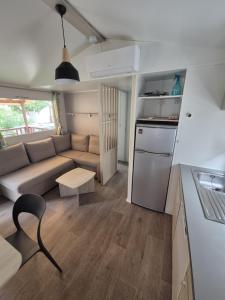 a small living room with a couch and a kitchen at Vias plage "MER & SOLEIL" Mobil home camping La Carabasse 6 a 8 personnes in Vias