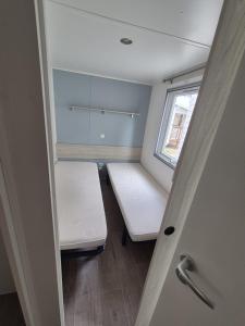 a small room with a bed and a window at Vias plage "MER & SOLEIL" Mobil home camping La Carabasse 6 a 8 personnes in Vias