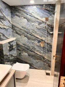 baño con aseo y pared de piedra en Newtown Inn Service Apartment, en Hulhumale 81 fotos más