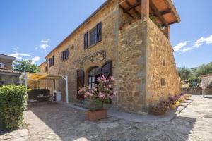 a stone building with flowers in front of it at La Fontaccia 13 by VacaVilla in Montiano