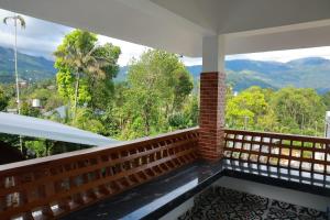 a balcony with a view of the mountains at Rain Drops Homestay in Anachal +13 photos