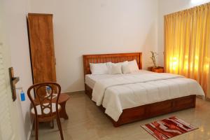 a bedroom with a large bed and a chair at Rain Drops Homestay in Anachal