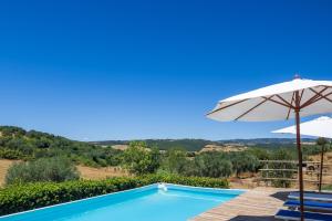 a villa with a swimming pool and an umbrella at La Fontaccia 13 by VacaVilla in Montiano