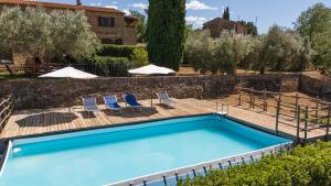 a pool with chairs and umbrellas in a yard at La Fontaccia 13 by VacaVilla in Montiano