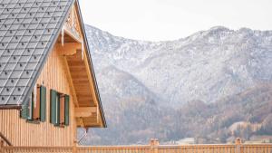 ein Haus mit einem Dach mit Bergen im Hintergrund in der Unterkunft Sunleitn-Residenz in Bad Goisern