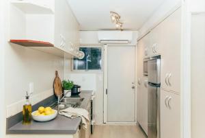 a kitchen with a sink and a refrigerator at 2 BR Unit Near the Beach Kohimarama in Auckland