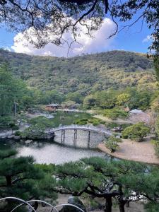 a bridge over a pond in a garden at 栗林公園の畔 in Takamatsu