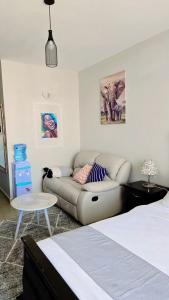 a living room with a couch and a bed at Affordable Luxury Ruaka in Ruaka