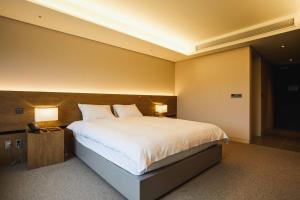 sypialnia z dużym łóżkiem i 2 lampami w obiekcie Phoenix Hotel Pyeongchang w mieście Pjongczang