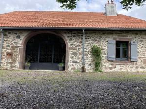 ein Steingebäude mit einer Tür und einem Fenster in der Unterkunft La Ferme Alter Native in Ternuay-Melay-et-Saint-Hilaire