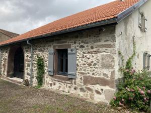 ein Steingebäude mit einem Fenster und einem roten Dach in der Unterkunft La Ferme Alter Native in Ternuay-Melay-et-Saint-Hilaire