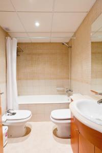 een badkamer met een toilet, een wastafel en een bad bij Apartamentos Port Cambrils in Cambrils