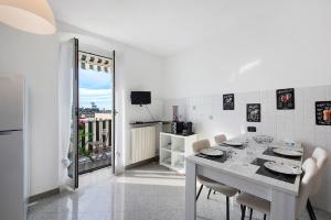 a white kitchen with a dining table and chairs at Mela Garden House in Genova