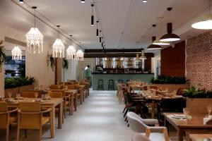 a restaurant with tables and chairs and a chef in the background at Asad in Astana