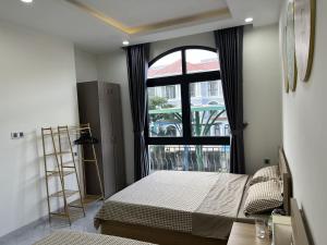 a bedroom with a bed and a large window at Sua Chua in Phú Quốc