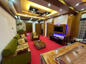 un soggiorno con divano e TV a schermo piatto di City view hotel & Apartment a Rajshahi