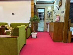una sala d'attesa con sedie verdi e un tappeto rosso di City view hotel & Apartment a Rajshahi