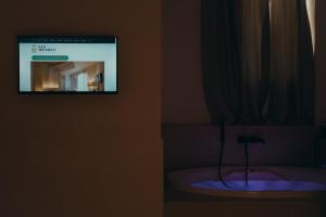 bagno con vasca e TV a parete di San Michele Rooms & Private Spa - via Santa Cesarea a Matera