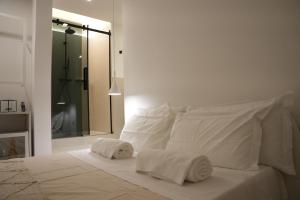 una camera da letto con un letto bianco con asciugamani sopra di San Michele Rooms & Private Spa - via Santa Cesarea a Matera