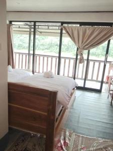 a bed in a room with a large window at BOUAKHAI HOTEL Pakbeng in Pakbeng