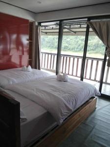 BOUAKHAI HOTEL Pakbeng في باكبنج: سرير كبير في غرفة مع نافذة كبيرة