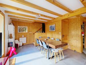 a dining room with a large wooden table and chairs at Chalet Casimir CSM CHARMING & NATURE 10 Pers in Châtel